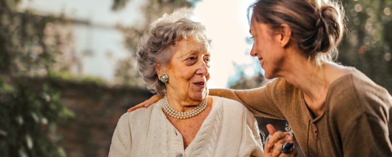 Women providing comfort to elderly woman